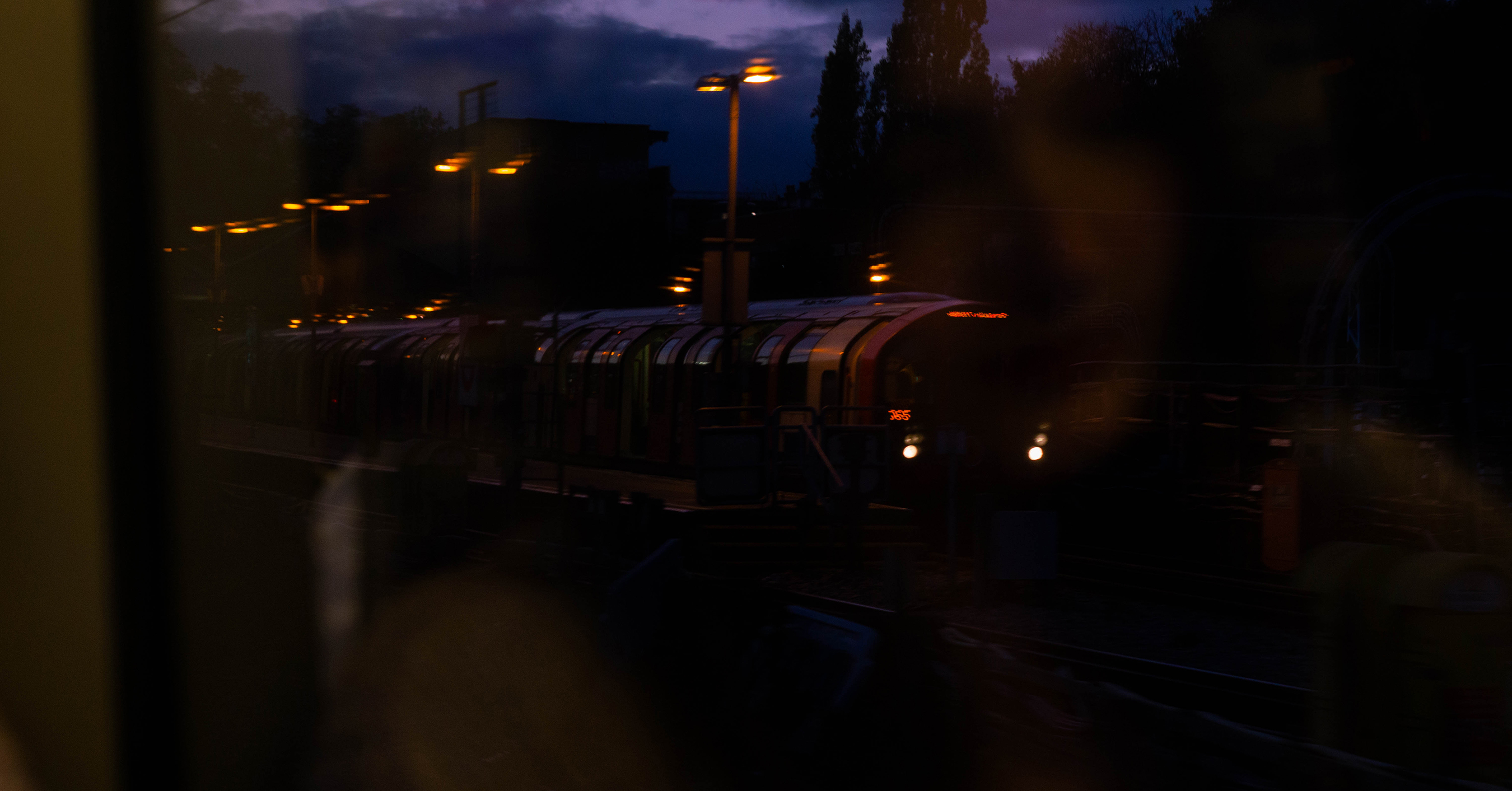 An image of a train at night with a woman's face translucently visible over the top.