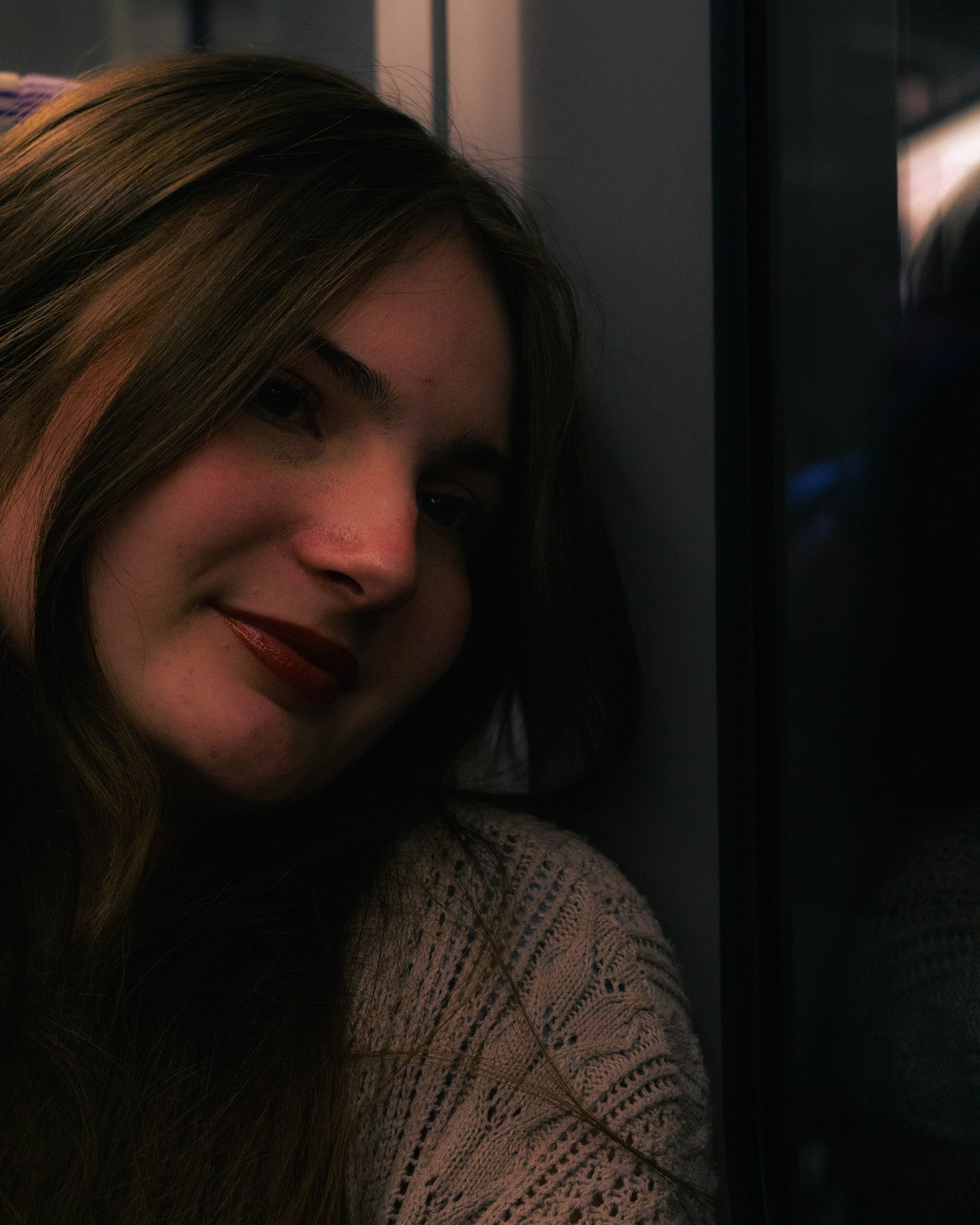 Photograph of a woman looking out of the window of a train.